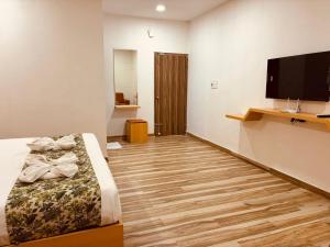 商沙巴Hotel Park Airport Zone Hyderabad的一间卧室配有一张床和一台平面电视
