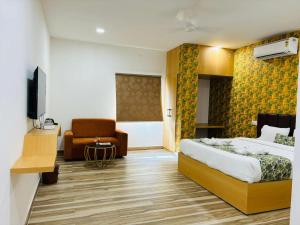 商沙巴Hotel Park Airport Zone Hyderabad的配有一张床和一把椅子的酒店客房