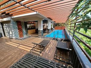 GoaSkon Baga Bliss Hotel by Orion Hotels的一座房子,设有一座带木甲板的游泳池