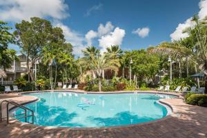 斯托克岛Coral Villa by AvantStay Close 2 DT Key West Shared Pool Month Long Stays Only的棕榈树度假村的游泳池
