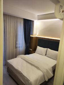 伊斯坦布尔Hotel Esve Istanbul的一间卧室配有一张带床头板的床和窗户