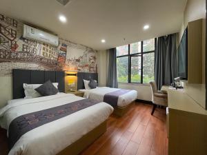 广州亿米酒店广州塔琶洲会展中心店的酒店客房设有两张床和电视。