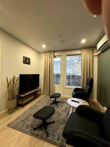 塞伊奈约基Kotimaailma Apartments#5 - Boheemi kaksio keskustassa的客厅配有沙发、椅子和电视