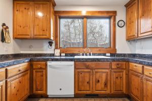 特柳赖德Russell Home by AvantStay Expansive Deck Stunning Views Hot Tub的厨房配有木制橱柜和白色洗碗机。