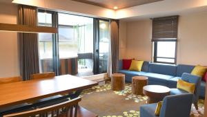 嬬恋村Karuizawakurabu Hotel 1130 Hewitt Resort的客厅配有蓝色的沙发和桌子