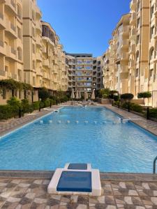 赫尔格达Apartments in Florenza Khamsin的一座大型游泳池,位于部分公寓大楼前