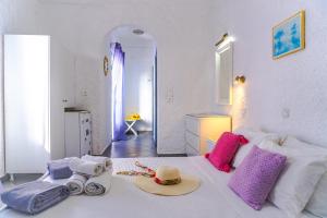 菲罗斯特法尼斯玛鲁拉别墅的一间白色的卧室,配有一张带帽子的床