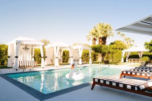 棕榈泉Hotel El Cid by AvantStay 16 OCC Full Hotel Buyout in Palm Springs w Pool的中间的游泳池,有天鹅