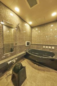 川崎SAKE Kura Hotel 川崎宿的大型浴室设有浴缸和淋浴。