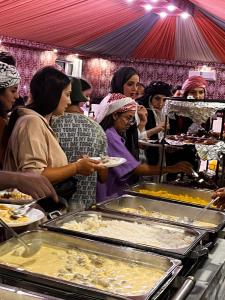 亚喀巴wadi rum guest house camp的一群人在自助餐中等待食物
