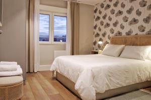 希洪Apartamentos Bahia San Lorenzo的卧室配有白色的床和窗户。