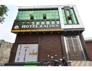 阿格拉Hotel Raj Inn, Agra的一辆酒店拉旅馆,摩托车停在旅馆前面