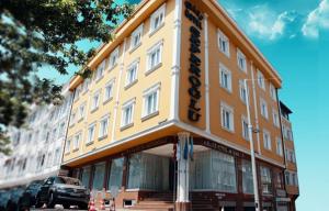 伊斯坦布尔Grand Hotel Seferoğlu的黄色的建筑,旁边标有标志