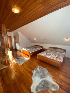 泽高杰耶泽尔斯科Rooms Kočna的铺有木地板的客房内的两张床
