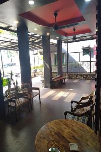 瓜埠Bull & Bear Airport Hotel Langkawi的一间带桌椅的餐厅以及一间设有窗户的房间