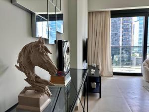 迪拜Burj Khalifa view - Modern 1BDR apartment的客厅里玻璃桌上的马雕像