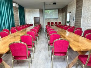 OsłowoCzar Podlasia agroturystyka的一间会议室,配有粉红色的椅子和一张大木桌