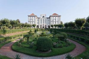 库里亚Curia Palace Hotel & Spa的一座大建筑,前面设有花园