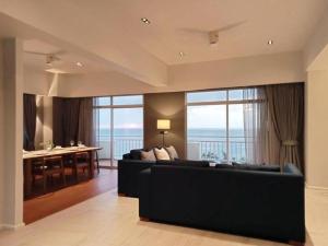 普吉镇Waterfront Suites Phuket by Centara NEW的客厅设有黑色沙发和大窗户