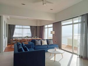 普吉镇Waterfront Suites Phuket by Centara NEW的客厅配有蓝色的沙发和桌子