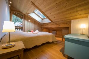 夏蒙尼-勃朗峰Chalets d'en haut - Bonheur - Happy Rentals的木屋内的卧室配有一张床