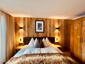 比希尔巴赫Sonn-Alm Chalet-Apartments的一间卧室设有一张床和木镶板墙
