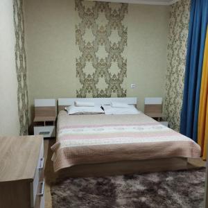 比什凯克Гостевой дом Энесай的一间卧室设有一张大床和一面墙