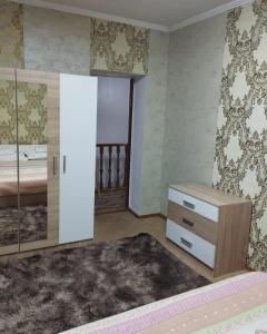 比什凯克Гостевой дом Энесай的一间卧室配有一张床、梳妆台和镜子