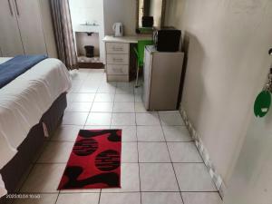 MtubatubaGREEN TREE的卧室配有一张床,地板上铺有红色地毯。