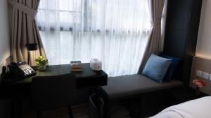 新加坡VicHaus Serviced Apartment的一间卧室设有书桌和窗户。