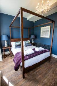 Upper ArleyThe Grange的一间卧室配有一张天蓬床和蓝色的墙壁