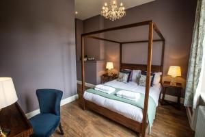 Upper ArleyThe Grange的一间卧室配有天蓬床和蓝椅
