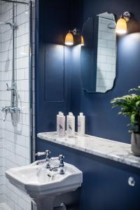 Upper ArleyThe Grange的蓝色的浴室设有水槽和镜子