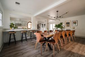 温莎Estrella by AvantStay Secluded Spanish-Style Estate on 7 Acres of Vineyards的厨房以及带木桌和椅子的用餐室。