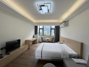 深圳WESU微宿服务公寓(深圳松坪山科技园店)的一间酒店客房,配有一张床和一台电视