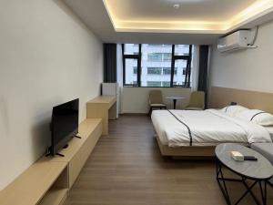 深圳WESU微宿服务公寓(深圳松坪山科技园店)的配有一张床和一台平面电视的酒店客房