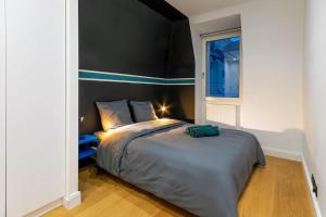 梅斯Le Verlaine的一间卧室配有一张大床和黑色床头板