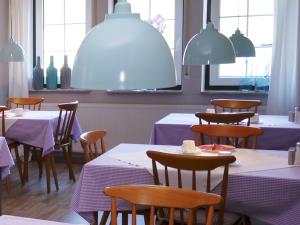 库克斯港吉克海滨酒店的一间设有紫色桌椅和窗户的用餐室