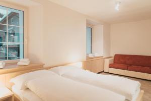 圣贝纳迪诺Lodge Brocco & Posta的一间卧室配有一张床和一张红色的沙发