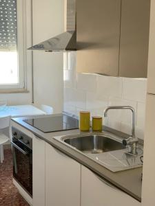 锡拉库扎Appartamenti di Casa VerbaVolant的厨房配有水槽和2杯水杯