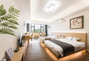 深圳WESU微宿服务公寓(深圳松坪山科技园店)的一间带两张床的卧室和一间带桌子的用餐室
