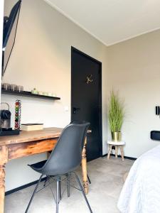 斯内克Bed & Breakfast Waterpoort - incl licht ontbijt的卧室配有书桌和椅子,位于门前