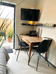 斯内克Bed & Breakfast Waterpoort - incl licht ontbijt的一张桌子、两把椅子和墙上的电视