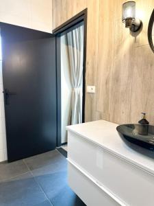 斯内克Bed & Breakfast Waterpoort - incl licht ontbijt的浴室设有黑色的门和水槽。