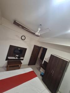 KalolHotel Nayan palace的卧室配有一张床,墙上挂着一个钟