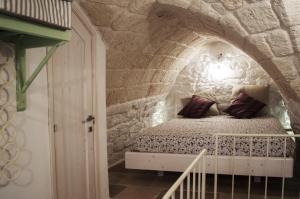 奥斯图尼30 Metri Quadri的卧室配有一张石墙床
