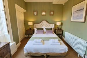 Upper ArleyThe Grange的一间卧室配有一张床,上面有两条毛巾