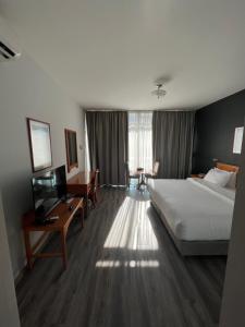 贝鲁特El Sheikh Suites Hotel的酒店客房配有一张床、一张书桌和一台电视。