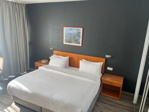 贝鲁特El Sheikh Suites Hotel的一间卧室配有一张带白色床单的大床