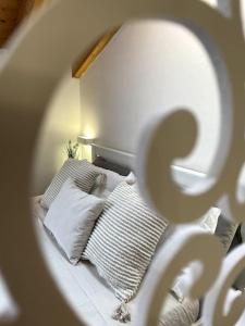 圣朱利亚诺米拉内塞Mansarda antica Milano的一间卧室配有带枕头和镜子的床
